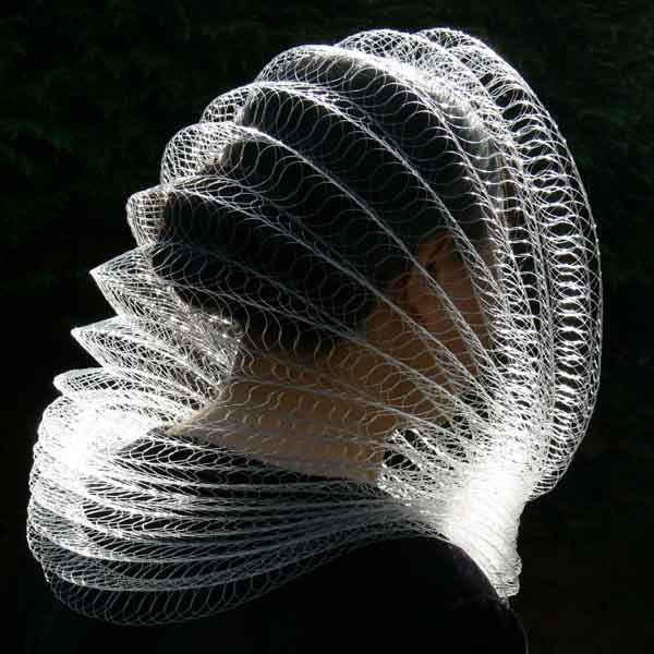 Armadillo|Armadillo 2007<br/>hood/ neck piece<br/>woven clear nylon<br/>diameter: 30cm / 12 inches<br/><br/>Inspired by the Clyde Auditorium, so called the Armadillo in Glasgow; I scaled own the zig zag roof  into a wearable hood/ neck piece. When worn it is a piece of jewellery or it can be converted into a private concert hall for listening to music.